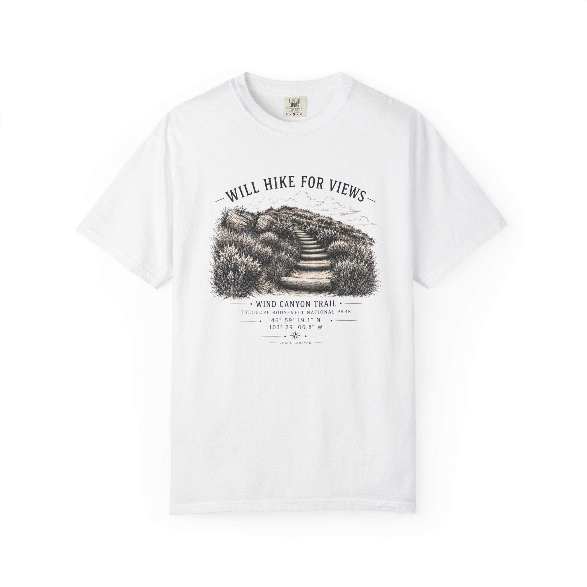 A white short-sleeve crewneck t-shirt featuring a black and white graphic print of a hiking trail on the front, with the text 'WILL HIKE FOR VIEWS' and 'WIND CANYON TRAIL'.