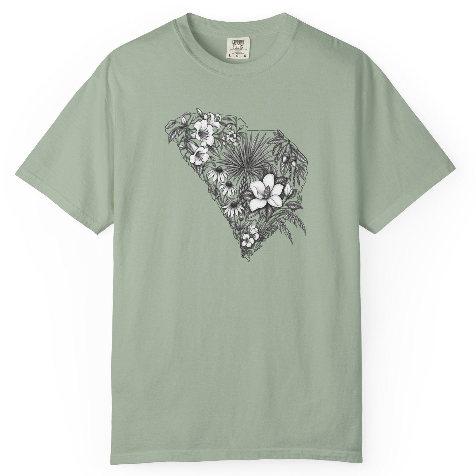 A sage green short-sleeve crewneck t-shirt featuring a black and white floral South Carolina graphic on the chest, displayed flat against a solid white background.
