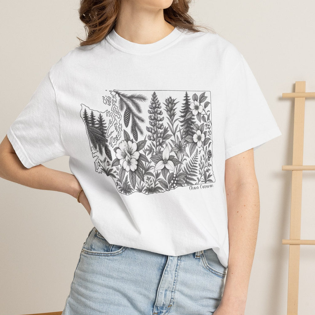 Person wearing a white t-shirt with Washington outlined and filled with floral drawings standing against a neutral background.