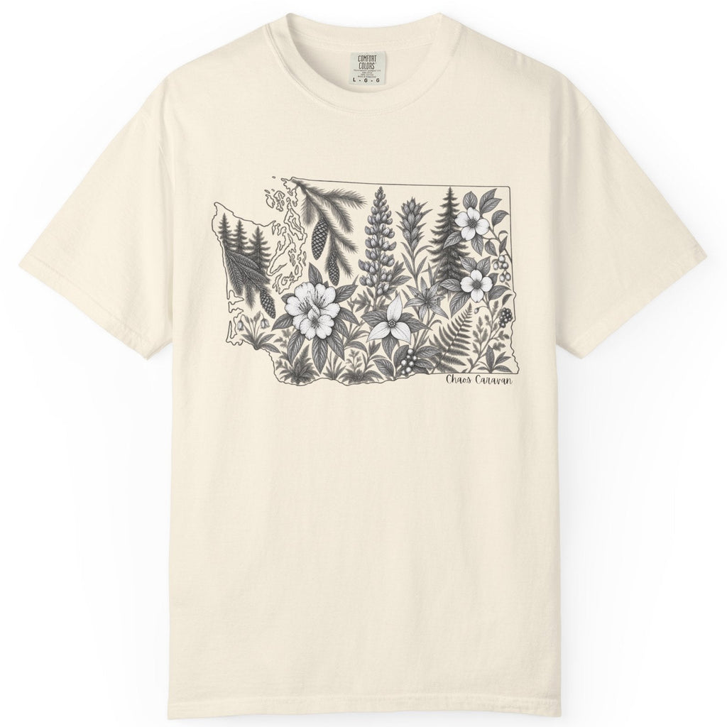 An off-white short-sleeve crewneck t-shirt featuring a black and white botanical illustration of the state of Washington filled with trees and wildflowers, with 'chaos caravan' printed below the graphic.
