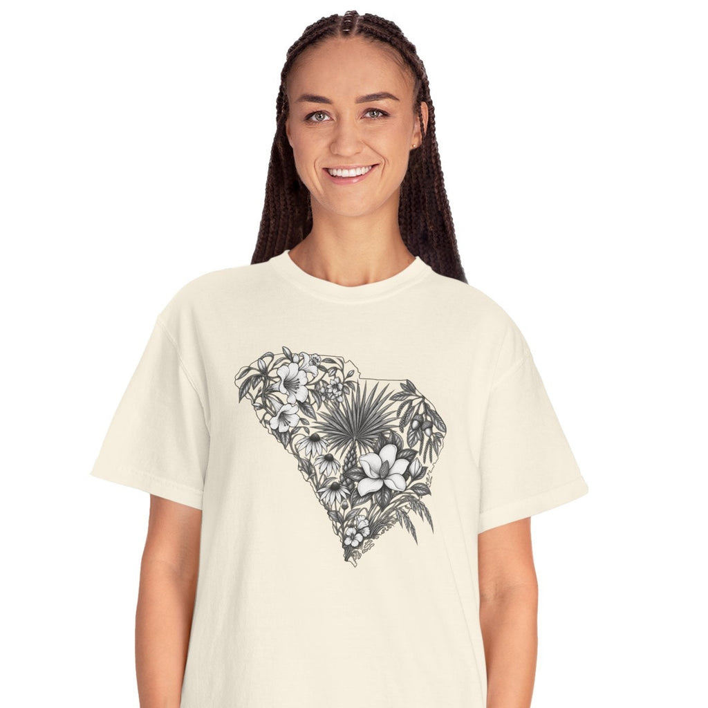 A woman modeling a cream-colored short-sleeve t-shirt with a black and white floral heart graphic on the front, paired with light blue jeans, against a plain white background.
