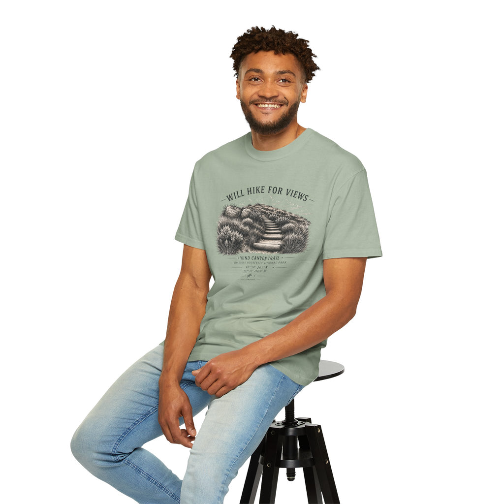 Man sitting on a stool wearing a green t-shirt with a graphic design.