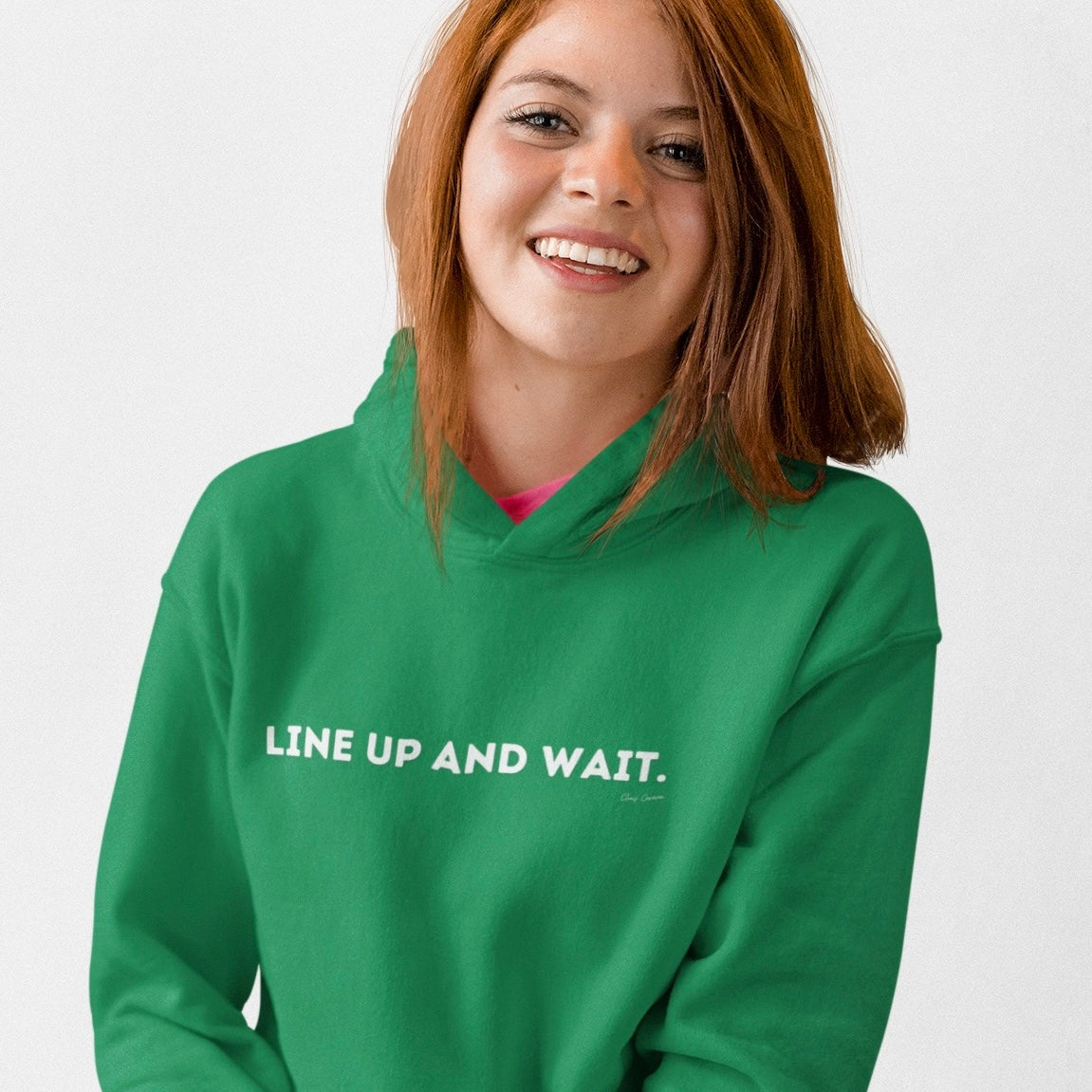 Person wearing a green hoodie with 'LINE UP AND WAIT.' text in white letters
